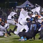 Nikiski running back Rykker Riddall (28) is tackled by Thunder Mountain's Sam Bluett (17), Kyrel Payne (38) and Mahina Toutaiolep (22) during the Bulldogs' 28-21 win over the Falcons in Juneau on Friday. Bulldog's blockers Luke Johnson (54), Corin Cooper (29), Jon McCormick (58), Ian Johnson (4) and Rueben Sepeda (75) are shown.