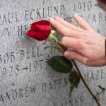A Juneau resident reaches out to an engraved name during the Blessing of the Fleet ceremony at the Alaska Commercial Fishermen's Memorial in May 2012.