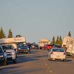 A "Bear jam" at Denali National Park and Preserve. Cars, campers and buses line both lanes of the highway and photographers gather to photograph a wild animal.