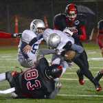 The Juneau-Douglas defense pulls down an Eagle River ball carrier during the Crimson Bears' 41-6 win over the Wolves on Saturday at Adair Kennedy Field.