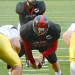 Juneau-Douglas High School sophomore John Elisoff prepares to hike the ball to quarterback Bubba Stults (17) during high school football action this season. Elisoff started as a freshman center and moved to tackle two games into this season.