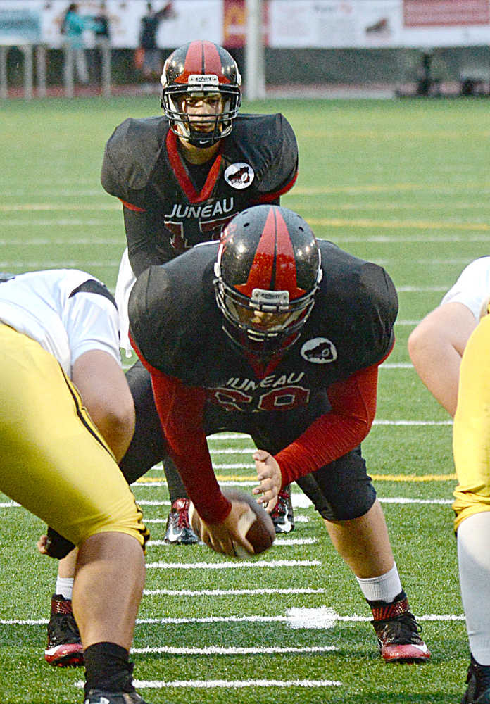 Juneau-Douglas High School sophomore John Elisoff prepares to hike the ball to quarterback Bubba Stults (17) during high school football action this season. Elisoff started as a freshman center and moved to tackle two games into this season.