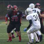 Juneau-Douglas senior Patrick Naputi (79) blocks for quarterback Bubba Stults (17) after hiking the ball during high school football action this season.