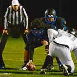 Thunder Mountain senior center Mason Kullander (52) prepares to hike the ball Falcons' sophomore quarterback Garth Tupou during high school football action this season.