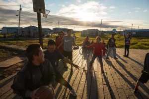 Youths play basketball at the community court in the village of Newtok on Aug. 4. The state is hoping to kick-start a mass exodus from the tiny village through a national competition for states and local governments vying for a slice of nearly $1 billion in grants to be awarded by the U.S. Department of Housing and Urban Development.