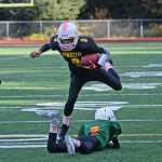 The Hawkeyes Luis Mojica (3) hurdles the Hurricanes Jaren Douglas (2) during the JYFL Senior Division championship game on Saturday at Adair Kennedy Field. The Hurricanes Masin Field (21) and Hawkeyes Dawson Hickok (75) are shown. The Hawkeyes won 18-12 and will travel to Anchorage next weekend while the Hurricanes play at Ketchikan. A slideshow of photos is online at juneauempire.com.