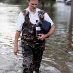 Rick Hoffman evacuates from his house, after making previous trips for personal items, in the Ashborough subdivision near Summerville, S.C., after many of their neighbors left Monday, Oct. 5, 2015. South Carolina is still struggling with flood waters due to a slow moving storm system. (AP Photo/Mic Smith)