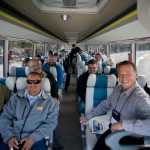 Dennis McDonnell, President of Alaska Coach Tours, right, and other attending the Alaska Travel Industry Association's Annual Convention & Trade Show ride an electric motor coach provided by BYD Auto Co., Ltd., a Chinese automobile manufacturer based in Shenzhen, Guangdong Province, to the Mendenhall Glacier Visitors Center to showcase the potential for electric vehicle bus transportation as part of the tourism industry in Alaska on Tuesday.