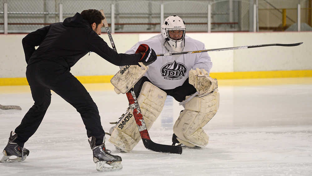 ProHybrid Goalie Training Camp instructor Zach Sikich works with adult goalie Darryl Tseu at the Treadwell Ice Arena last week.