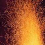 Glowing embers of a camp fire.