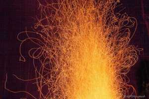 Glowing embers of a camp fire.