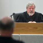 Juneau District Court Judge Thomas Nave speaks to John Forrest after closing statements in Forrest's lawsuit against Kathleen Turley for springing his traps on the Davies Creek trail in December. Judge Nave is to issue a judgment by noon on Friday.