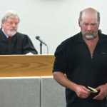 John Forrest retrieves his trapping license from Juneau District Court Judge Thomas Nave after closing statements in his lawsuit against Kathleen Turley for springing his traps on the Davies Creek trail in December. Judge Nave is to issue a judgment by noon on Friday.