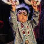 Joy John, 2, of Anchorage, Alaska, performs with the Acilquq Drummers and Dancers during the annual Alaska Federation of Natives conference in Anchorage, Alaska,, Thursday, Oct. 15, 2015. The convention is annually the largest gathering of Alaska Natives in the state every year.  (AP Photo/Mark Thiessen)