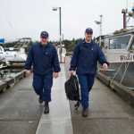 U.S. Coast Guard Petty Officer Second Class Chris Houverner, left, and Petty Officer First Class Ben Stixrud walk the dock at the Don Statter Memorial Boat Harbor in Auke Bay after making a boat safety exam on Friday.