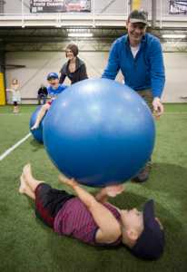 Steve Carlton and his wife, Heather, play with their children, Theo, 3, below, and Arlo, 5, during the Moon Walk for Alaska Day at the Dimond Park Fieldhouse on Monday.