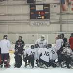 The JDHS Crimson Bears hockey team gather around head coach Luke Adams as practice ends Wednesday morning on the Treadwell Arena ice.