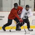 JDHS freshmen Logan Ginter and Blake Bixby work for puck control during Wednesday morning practice at Treadwell Arena.
