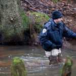 Juneau Police Department Detective Sterling Salisbury searches in Duck Creek on Thursday near the Kodzoff Acres Mobile Home Park. Christopher D. Strawn , 32, has been arrested and charged in the murder of Brandon C. Cook, 30, who was killed in Kodzoff Acres on Tuesday.