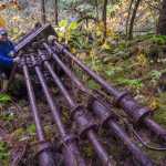 Greg Taylor poses next to half of a Risdon 10 stamp mill.