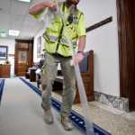 Brad Berens of Dawson Construction pulls up carpet protection at the Capitol on Wednesday. Construction workers are getting the building ready for the Special Session that starts on Saturday.