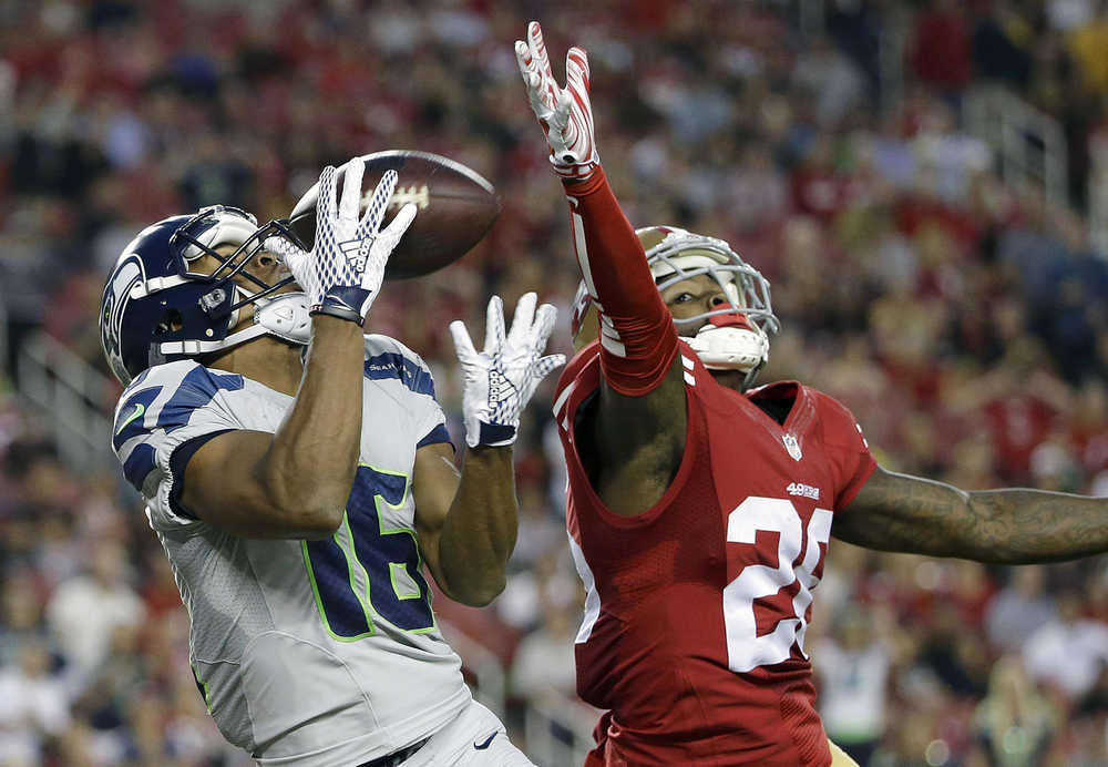 Seattle Seahawks wide receiver Tyler Lockett (16) catches a touchdown pass in front of San Francisco 49ers cornerback Tramaine Brock (26) during the first half of an NFL football game in Santa Clara, Calif., Thursday, Oct. 22, 2015. (AP Photo/Marcio Jose Sanchez)