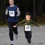 Shawn Miller, age 35, follows Michael Miller, age 6, towards the finish of Juneau's 1st Annual PolioPlus Fun Run on Saturday at the Riverbend Elementary School covered playground. A slideshow of photos is online at Juneauempire.com.