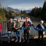 Lt. Gov. Byron Mallott, second from left, helps Roy Peratrovich, Jr., cut a ribbon as Sandra Garcia-Aline, of the Federal Highway Administration, left, Sasha Soboleff, Grand President of the Alaska Native Brotherhood, Johanna Dybdahl, Grand President  of the Alaska Native Sisterhood, and Marc Luiken, Commissioner of the Alaska Department of Transportation and Public Facilities, right, hold a ribbon during the rededication ceremony for the Brotherhood Bridge on Saturday.