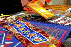 In this Oct. 15 photo, Dr. Paul Landen, an associate professor of psychology at Kenai Peninsula College, displays woven tapestries, a prayer flag and a book of Buddhist doctrine purchased on his travels to Bhutan, during a talk at the Soldotna college.