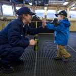 BM2 Julia Kinney gets a high-five from Parker Abbott, 2, on the bridge on the polar icebreaker U.S. Coast Guard Cutter Healy Friday. The ship stopped in Juneau during a return trip to it's Seattle base after it's Arctic West Summer 2015 science mission.