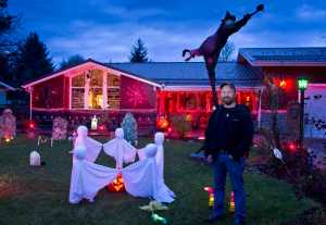 Dan Earls poses for a picture in his front yard decorated for Halloween. "I like Halloween and the neighborhood sure likes it," says Earls. Earls is also turning his garage into a seven-room haunted house for trick-or-treaters to venture through Saturday night. "I work as a mechanic so this is my fun thing."