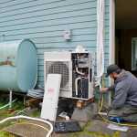 Jake Eames, right, and David Nash install an air-to-air heat pump system to a Mendenhall Valley home Thursday that formerly was using oil for heating.
