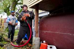 Phil Isaak, right, and Nik Reis of Ike's Fuel finish filling a home heating oil tank downtown on Friday.