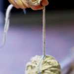 Ricky Tagaban prepares a warp of red cedar bark and merino wool for a future Chilkat weaving during a weavers exhibit in the lobby of Centennial Hall on Thursday during "Sharing Our Knowledge," a three-day conference of Tlingit tribes and clans.