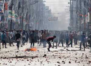 Ethnic Madhesi protesters throw stones and bricks at Nepalese policemen in Birgunj, a town on the border between India and Nepal on Monday.