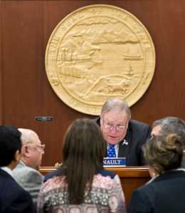 Speaker of the House Mike Chenault, R-Nikiski, talks with legislators at his desk during an "at ease" in the House of Representatives at the Capitol on Monday.
