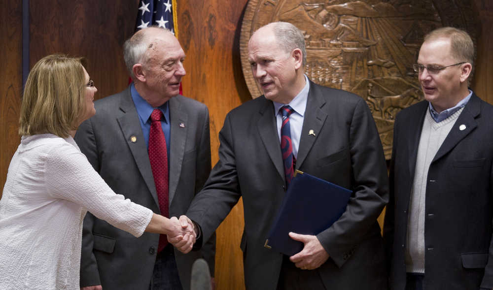 Gov. Bill Walker shakes hands with Sen. Anna MacKinnon, R-Eagle River, left, Rep. Steve Thompson, R-Fairbanks, and Rep. Mark Neuman, R-Big Lake, right, after signing the bill to buyout TransCanada's share of the AKLNG project at the Capitol on Thursday.