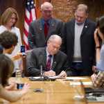 Gov. Bill Walker signs the bill to buyout TransCanada's share of the AKLNG project as Sen. Anna MacKinnon, R-Eagle River, left, Rep. Steve Thompson, R-Fairbanks, and Rep. Mark Neuman, R-Big Lake, right, watch at the Capitol on Thursday.