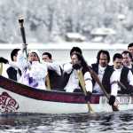 Ethel Lund holds the Olympic flame high as members of a Tlingit canoe team paddle across Juneau's harbor toward the Intermediate Vessel Float during the 2002 Olympic Torch Relay in January, 2002.