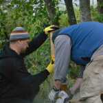 Volunteers install fence posts along Jordan Creek.