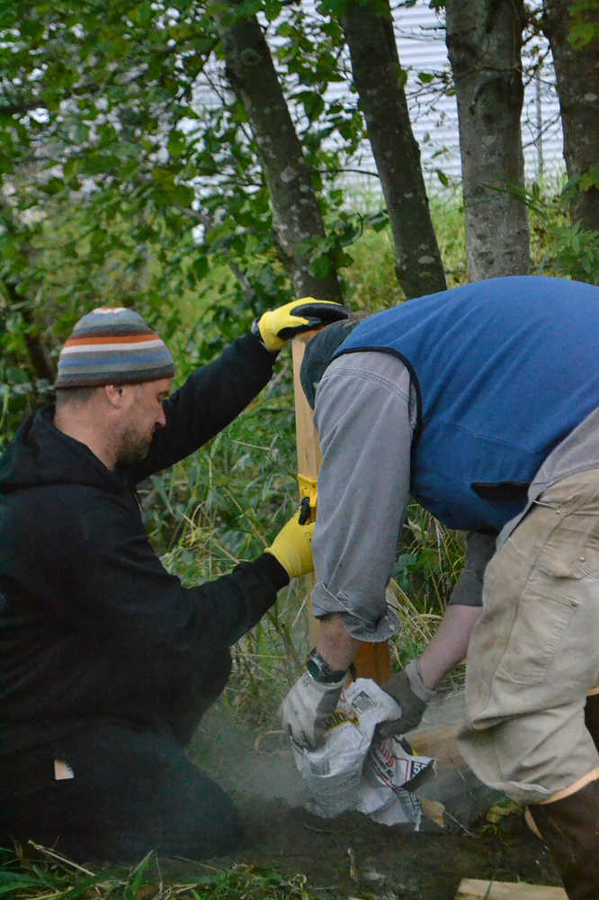 Volunteers install fence posts along Jordan Creek.