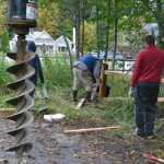 Volunteers work to install a split rail cedar fence along Jordan Creek. They hope the fence will prevent plowed snow, and its accompanying contaminants, from entering the creek.