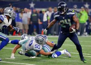 Seattle Seahawks running back Marshawn Lynch (24) breaks through a tackle-attempt by Dallas Cowboys' Sean Lee (50) as Cowboys Byron Jones, left, comes over to help on the running play in the second half of an NFL football game Sunday, Nov. 1, 2015, in Arlington, Texas. (AP Photo/Brandon Wade)