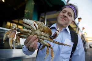 In this photo taken Nov. 10, Michael Bair, of Lexington, Kentucky, holds an imported Dungeness crab from the Northwest at Fisherman's Wharf in San Francisco.