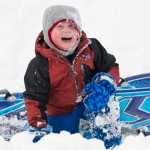 Oscar Lamb, 3, laughs after crashing into a snowbank while on an outing with his pre-school group, Neighborhood Kids, at Eaglecrest on Monday. The National Weather Service calls for continued snow showers throughout the week.