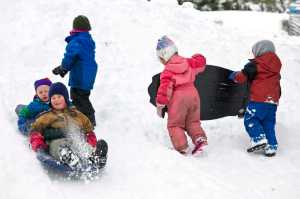 Henry Maier, 4, and Alexander Andrews, 3, sled past other members of Neighborhood Kids pre-school during an outing at Eaglecrest on Monday.