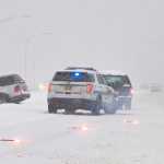A Juneau Police Department officer responds to a vehicle in the meridian on Egan Drive Wednesday morning.