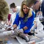 Teacher Rebecca Farrell helps Gabe Miller dissect a jack king salmon at Floyd Dryden Middle School on Friday.