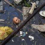 In this Nov. 5 photo, trash floats in the Meriti River, which flows into Guanabara Bay in Rio de Janeiro, Brazil. The dozens of rivers that crisscross metropolitan Rio dump hundreds of millions of liters of raw sewage into the bay each day.