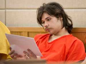 Kevin Scott Nauska, 19, reads his charging documents in Juneau District Court on Friday before his arraignment on charges of second-degree murder and assault charges in the stabbing death of Jordon J. Sharclane, 37, and stabbing injuries to Sharclane's son, Michael, 19.